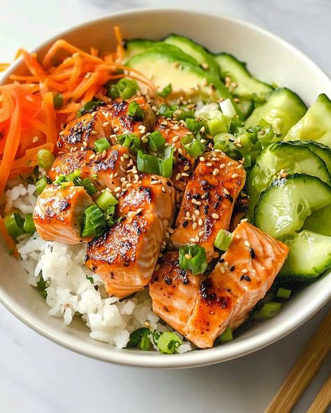 Advertisement These Crispy Salmon Bowls combine the tender flakiness of baked salmon with the creamy richness of avocado and the crunch of fresh cucumber and carrots. The soy-based sauce ties ... Read more Baked Salmon Bowl Recipe, Whole 30 Salmon Bowl, Easy Salmon Rice Bowl, What To Have With Salmon, Salmon Protein Bowl, Salad For Salmon, Crispy Salmon Bowl, Salmon Meal Ideas, Salmon Bowls Healthy