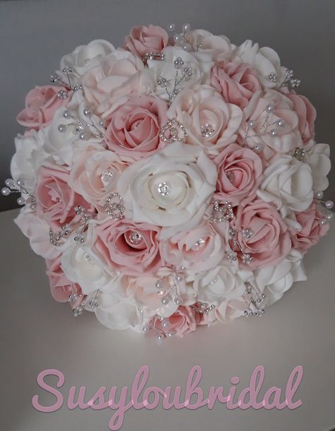 "A Beautiful, Romantic Fairytale Bouquet in two tone Dusky Pinks and White Roses with a large diamante in each Rose. It has White Pearl sprays, Silver and White Bead Cluster Sprays and Diamante Hearts throughout this Bouquet. The Roses are foam and are completely colourfast. The handle is covered in quality Dusky Pink Satin with Two Bows either side of the handle and finished with Diamante trim at the top of the handle. This Bouquet looks and feels gorgeous and has been made to a very high stand Beautiful Wedding Bouquet, Pink Rose Wedding Decor, Wedding Pink Roses, Pink Quince Bouquet, White And Light Pink Bouquet, White Gold And Pink Wedding, Pink And White Wedding Decorations, Wedding Bouquet Aesthetic, Baby Pink Wedding Theme