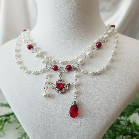 Red and White Beaded Angelcore Necklace with Silver Plated Heart Wing Charm Available in my Etsy shop ExangelsJewelry.etsy.com . . #angelcoreaesthetic #angelcorenecklace #whitebeadedjewelry #grungenecklace #fairycorejewelry #fairycorenecklace #handmadejewelry #beadednecklace #chunkynecklace #princesscorejewelry #princesscoreaesthetic #aestheticgrunge Fairycore Necklace, Grunge Necklace, Red Beaded Necklaces, Pretty Jewelry Necklaces, Pearl Necklace Designs, Diy Jewelry Unique, Tooth Necklace, Polymer Clay Jewelry Diy, Bead Charms Diy