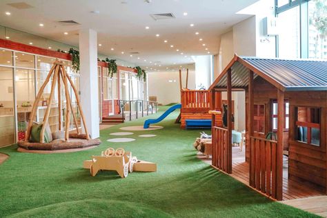 An indoor childcare playground with grass as the floor and a mini wooden house and slide. Preschool Montessori, Learning Preschool, House Slide, Explorers Club, Montessori Playroom, Newcastle Nsw, Preschool Programs, Outdoor Play Area, Montessori Preschool