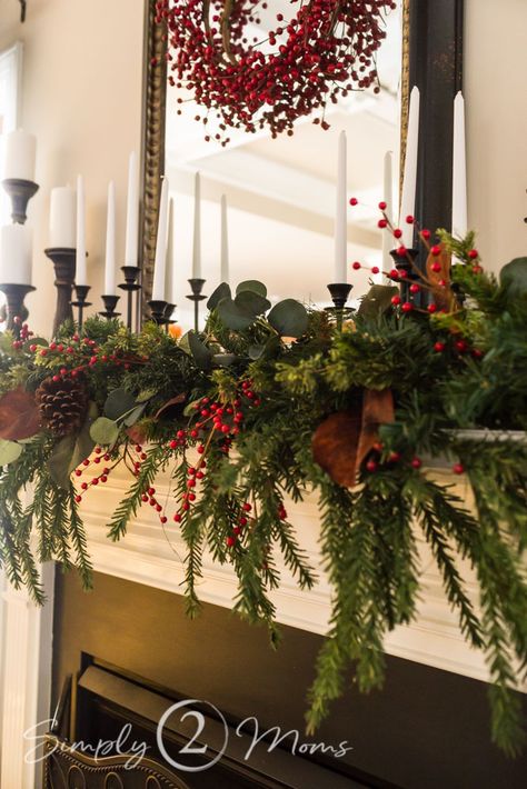 My halls are decked with classic, southern-style charm. Grab a cup of coffee and tour my home that features simple ideas you can easily do in your own home! Includes a cozy front porch, foyer, kitchen, family room with a stunning fireplace mantel, and powder room. #redberries #redberrywreath #cozychristmas #christmas #mantle #centerpiece #traditional #vintage #housetour #bathroom #foyer #kitchen #familyroom #frontporch Christmas Mantle Traditional, Traditional Cozy Christmas Decor, Christmas Mantle With Wreath, Classic Christmas Fireplace Decor, Christmas Mantle Decor Traditional, Classic Christmas Centerpieces, Classic Christmas Mantle Decor, Traditional Red Christmas Decor, Craftsman Christmas Decor