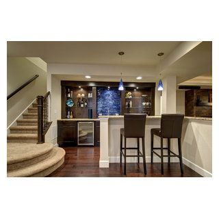 Walk behind wet bar with wood floors, glass shelves, built in wine cooler and blue accent tile. ©Finished Basement Company Lower Level Bar, Transitional Basement, Built In Wine Cooler, Home Bar Areas, White Tile Backsplash, Basement Inspiration, Home Bar Design, Basement House, White Backsplash