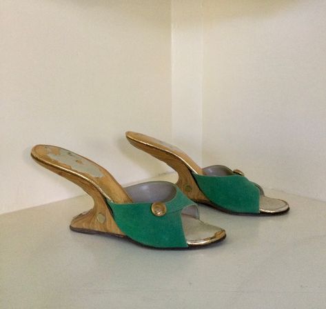 "Rare 1950s green suede boomerang mules with wooden heels.  Vamps are decorated with a golden button ornament and heels have golden disks running along the back curve and on the sides.  Size reads 7N but please refer to measurements below.  They probably fit more like a 6 1/2. Nice vintage condition.  One of the golden accents at the back of the heel is missing and the insoles have lost their shine in areas. This is not visible when worn as it's covered by your foot. There is a tiny notch in one Vintage Wedge Heels, Hippie Shoes, Wooden Heels, Vintage Heels, Unique Shoes, Wooden Heel, Green Suede, Pretty Shoes, Dream Shoes