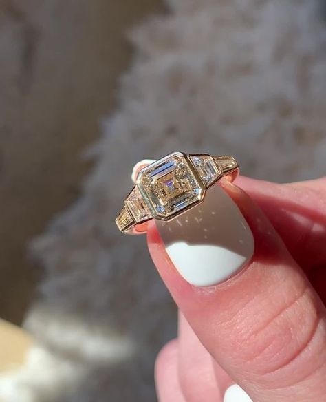 Frank Darling Custom Rings on Instagram: "Our Deco Bullet is named for its namesake bullet shaped side stones– but this time we swapped them out for some thinner tapering baguettes 😍⁠ ⁠ This bezel set beauty features a warm 2.44ct J color asscher diamond made warmer by its 18k yellow gold setting. Bezel set trapezoid and tapered baguettes maximize finger coverage for a look that Gatsby would envy.⁠ ⁠ The Ring:⁠ • 2.44ct Asscher⁠ • J Color, VS1⁠ • 4.25 x 2.25 x 1.5 mm side stones⁠ • 18k YG⁠ ⁠ #f Vintage Bezel Set Engagement Ring, Art Deco Asscher Engagement Ring, Antique Bezel Engagement Ring, Art Deco Bezel Engagement Ring, Ascher Cut Diamond Engagement Ring Bezel, Asscher Bezel Engagement Ring, Engagement Rings Bezel Set, Vintage Asscher Engagement Ring, Vintage Bezel Engagement Ring