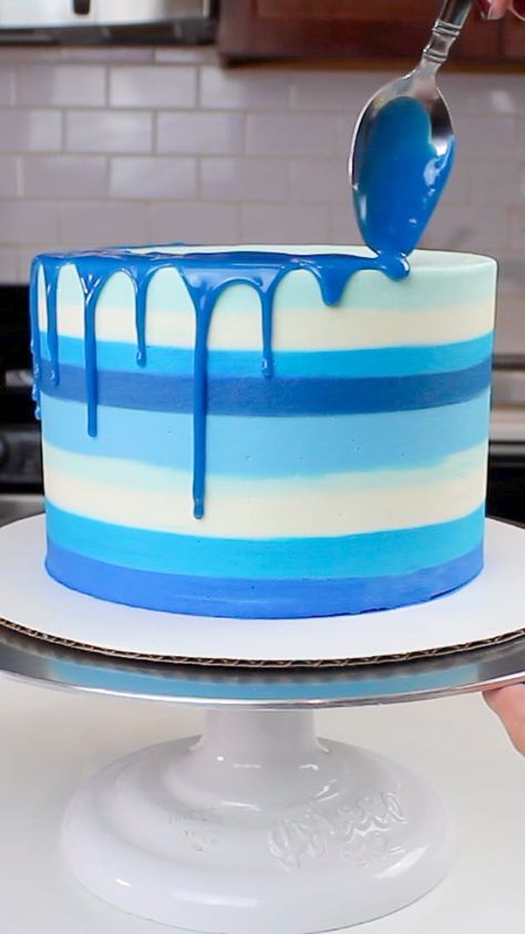 image of a blue colored drip being added to a striped blue cake Blue Drizzle Cake, Blue Drip Cake For Men, Drip Cake Ideas For Men, Blue Icing Cake, Drip Cake Recipe, White Drip Cake, Hanukkah Cake, Blue Drip Cake, Buttercream Drip