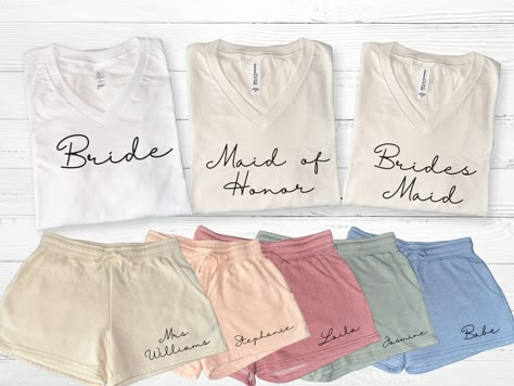 Personalized bridal party getting ready outfits for bride and bridesmaids. Perfect to wear on wedding day or bachelorette party.  Versatile set to use as pajamas, loungewear, or casual wear.  Mix and match shorts to match wedding theme. These sets make great bridesmaid gifts or proposal gift for bridal party.  Available in sizes XS to 2XL in dusty rose, blush, bone, sage, and misty blue shorts.  FREE STANDARD SHIPPING WITH ORDER OVER $35  ♥SHIRT AVAILABLE IN WHITE AND IVORY V NECK ONLY TO BEST M Wedding Party Pajama Set, Matching Bridesmaids Getting Ready, Bridesmaid Shirts Getting Ready, Wedding Day Gifts For Bridesmaids, Bridesmaid Morning Outfit, Bridesmaid Party Ideas, Bridesmaid Gifts From Bride Day Of, Clothing Product Shots, Getting Ready Outfits For Bridesmaids