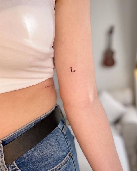 Letter L Tattoo Ideas Initials, Typewriter Letter Tattoo, Typewriter Font Tattoo Initials, Letter Tattoo Placement Ideas, Child Initial Tattoo Ideas, Minimalist Initial Tattoo, Letter Arm Tattoo, Letter Fonts For Tattoos, L Initial Tattoo