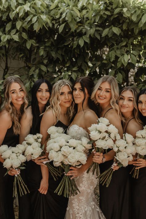 Modern Moody El Chorro Wedding - Scottsdale wedding design with white flowers and desert mountain views. Long stem white rose bouquet. Bridesmaids wore black dresses and carried white flower bouquets. Floral columns were featured in the ceremony. The reception had candles and bud vases with white flowers. Black signs and accents were used in the ceremony and reception. Photos by Emerald AZ. Long Stemmed Bridesmaid Bouquet, White Flowers With Black Center, Emerald Bridesmaid Dress Bouquet, All Black Wedding Flowers, Black White Bridal Bouquet, Long Stem White Rose Bouquet Bridesmaid, Black And White September Wedding, Black Bridesmaid Dresses With Bouquets, Black Bridesmaid Dresses With White Flowers