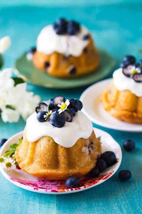 closeup of mini blueberry bundt cakes on a white platter in front of two other cakes Blueberry Cakes, Blueberry Mousse, Moist Blueberry Cake, Healthy Blueberry Cake, Speciality Cakes, Lemon Blueberry Bundt Cake, Blueberry Cake Mix, Blueberry Bundt, Blueberry Bundt Cake