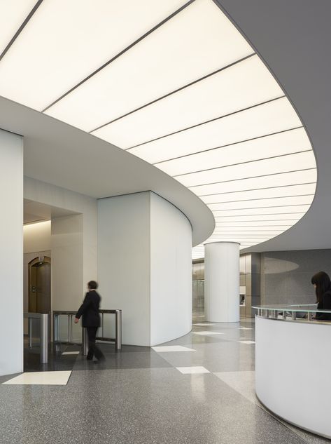 A substantial renovation of the iconic US Bank Tower in downtown Los Angeles by new owners OUE included this spectacular lobby upgrade. A luminous arc provides a focal point for the reception area beneath a large digital art display and the illumination delivered acts as a comfortable transition from daylight into the interior while providing wayfinding to the elevator area for visitors. ARCHITECT: Gensler / LIGHTING DESIGN: Lighting Design Alliance / Photo: ©Gensler/Ryan Gobuty #lighting #light Luminous Ceiling, Us Bank Tower, Aesthetic Lighting, Lobby Lighting, Us Bank, Interior Design Layout, Design Strategies, Build Design, Modern Office Space