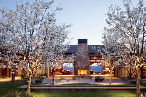 A fireplace anchors a courtyard off the great room of Dana Johnson and Mark Nelson’s 10,000-square-foot residence. They commissioned architect Howard J. Backen to create the house and a winery on the 300-acre property in Napa Valley. Mark W. Bowers was the landscape architect. Rustic Home Exterior, Country Interior Design, Outdoor Fireplace Designs, Modern Country Style, Country House Design, Country House Interior, Wine House, Wine Country California, Country Homes