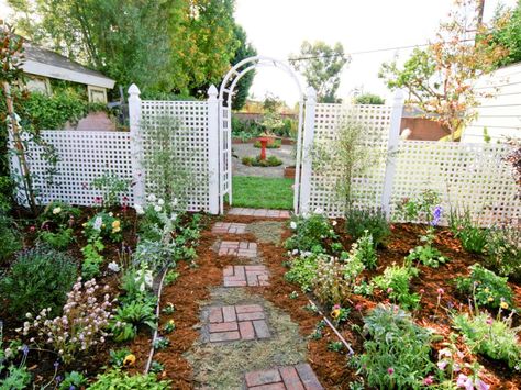 A brick walkway winds through a cottage-style garden with a crisp white lattice fence and arbor. Carport Landscaping, Brick Walkway Ideas, Open Carport, Entryway Flowers, Arched Entryway, Brick Pathway, Garden Nook, Pathway Landscaping, Brick Walkway