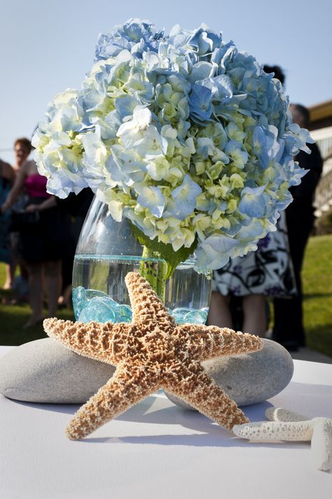 This flower arrangement was placed on the signing table. Under The Sea Floral Arrangements, Under The Sea Flower Arrangements, Beach Theme Centerpieces, Beach Cottage Design, Beach Centerpieces, Beach Decorations, Vase Ideas, Under The Sea Theme, Baby Shower Flowers