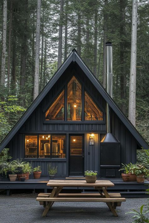 A Frame Cabin Lighting, Small Black Cabin, Dark A Frame House, A Frame In The Woods, Black A Frame Cabin, Black Cabin Exterior, Small Forest House, Cozy Cabin In The Woods Interiors, Dark Cabin