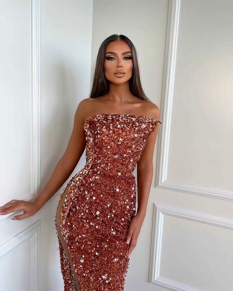 Share with a friend or tag a friend who would look exquisite in this gown! To order this mesmerizing copper gown, send us a DM at @reineecouture. This captivating copper gown is the epitome of haute couture, blending bold glamour with intricate detailing. The plunging halter neckline is framed by a cascade of shimmering embellishments, leading the eye down to the form-fitting silhouette that beautifully hugs your figure. The asymmetrical ruffled shoulder adds a striking, artistic element, ma... Prom Dresses Shiny, Coral Gown, Custom Made Dresses, Silver Gown, Sequin Evening Gowns, Exquisite Gowns, One Shoulder Gown, Embellished Gown, Stunning Gowns