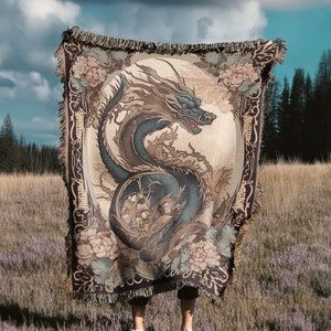 Transform your space with our Floral Pink Dragon Throw Blanket Tapestry Rug, a perfect blend of Chinese vintage charm and cozy cottagecore warmth. 🌸 Crafted from 100% cotton jacquard knit, this woven masterpiece is irresistibly soft, making it ideal for snuggling on the couch, outdoor adventures, or cozy moments by the fireplace. 🏡 A thoughtful housewarming gift for her or any nature dragon lover. Elevate your decor with this mythical art piece. 🎁✨ Japanese Dragons, Medieval Japanese, Utagawa Kuniyoshi, Medieval Tapestry, Pink Dragon, Japanese Dragon, Loom Pattern, Woven Throw Blanket, Dragon Lover