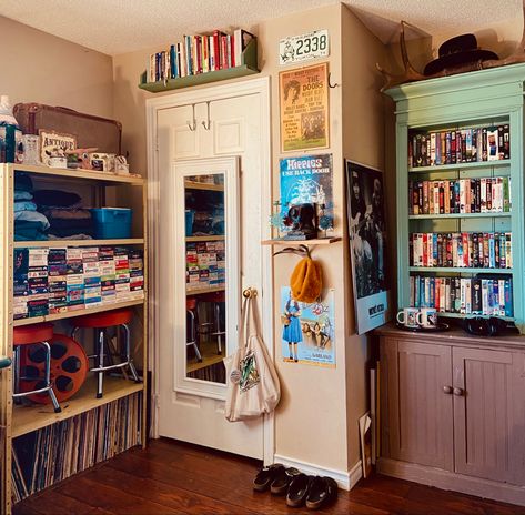 70s style room with vintage and second hand furniture. Old music and movie posters on the wall and shelves with an assortment of clothes and VHS tapes. Western Decorations, 70s Room, Vhs Collection, Western Room, Orange Room, 80s Western, Western Living Room, Western Rooms, Orange Rooms