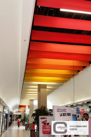 Carrefour retail superstore. France. Materials: Suspended ceiling clouds using Standard Color 705C fabric. Ceiling Wayfinding, Ceiling Clouds, Baffle Ceiling, Acoustical Ceiling, Retail Facade, Acoustic Ceiling, Corridor Design, School Interior, Ceiling Treatments