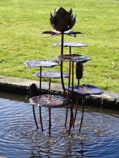 A small fountain based on the sacred lotus plant. The lotus flower at the top of the fountain with nests of petals and the rounded leaves below are all beaten to shape by hand. Water wells up in the flower and falls successively into pools in the the leaves below. It makes a musical splashing sound. Light is reflected in the leaves and in the streams of falling water. The fountain is suitable fro a small garden or courtyard. 75cm high:  £1,960 Lotus Sculpture Art, Lotus Fountain, Ponds Backyard Waterfall, Copper Fountain, Garden Fountains Outdoor, Lotus Sculpture, Lotus Plant, Outdoor Water Features, Garden Water Fountains