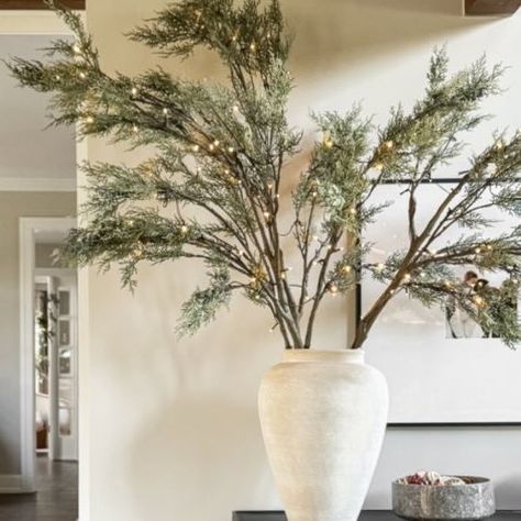 Lauren Hansen on Instagram: "PRE LIT JUNIPER STEMS 🫶🏼 comment LINKS and I’ll send it to your inbox! These oversized pre lit berry juniper branches are the perfect addition to our great room. Use in a vase on a sideboard/console OR in a floor planter - they’re sturdy, tall, and can be set to a timer!" Vase With Christmas Greenery, Large Vase Christmas Decoration, Tall Glass Vase Christmas Decor, Christmas Branches In Vase, Christmas Floor Vase Ideas, Christmas Stems Vase, Large Vase Decorating Ideas, Tall Christmas Centerpieces, Floor Vase With Branches