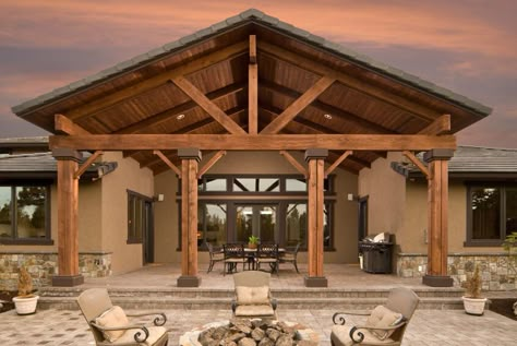 Even the rear of this home includes a grand architectural statement. Tall wooden beams lead up to a massive arched patio cover. The beautiful stone patio continues into a fire pit area with four elegant armchairs. Porch Cover, Cedar Porch, Covered Patio Design, Building A Porch, Covered Patios, Patio Covers, Patio Roof, Wood Patio, House With Porch