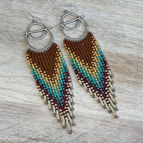 Beaded fringe earrings in rust, turquoise, red, and yellow tones, suspended from silver hoops. Details~ * Made with glass seed beads and sterling silver ear wires, suspended from silver plated alloy frames. * Length: Drop length (including ear wire) is approximately 12 cm. Width is slightly under 3 cm.  * Packaging: Your order will arrive lovingly packaged in a gift box, wrapped with a ribbon and ready for gifting. * Please visit my Etsy shop for a full selection of my handmade jewelry: https:// Indigenous Beading, Stitch Earrings, Beaded Fringe Earrings, Beading Jewelery, Brick Stitch Earrings, Beaded Tassel Earrings, Yellow Tones, Beaded Fringe, Southwestern Style