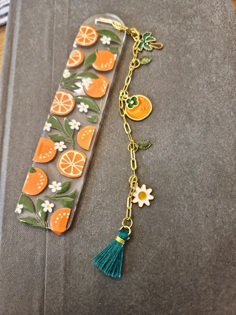 Cute acrylic bookmark with oranges decal. Gold chain with assorted funky charms makes up the tassel. How To Make Bookmarks Diy, Orange Bookmark, Acrylic Bookmark Ideas, Bookmarks Acrylic, Polymer Clay Bookmark, Girls Night Crafts, Charm Bookmark, Bookmark Ideas, Creative Bookmarks