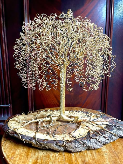 A beautiful and elegant Weeping Willow Tree design, mounted on a rare black walnut base. This unique piece is sure to catch everyone's eye and is best placed in a sunny location to capture the reflective properties of the metal. Copper, silver, gold, and black colored non-tarnish wire were used to craft this one-of-a-kind sculpture measuring 12 inches high, mounted on a walnut base measuring 12x7 inches. Copper Wire Crafts, Twig Art, Wire Sculptures, Wire Art Sculpture, Wire Wrapped Stone Jewelry, Wire Tree Sculpture, Wire Trees, Diy Wall Art Decor, Weeping Willow