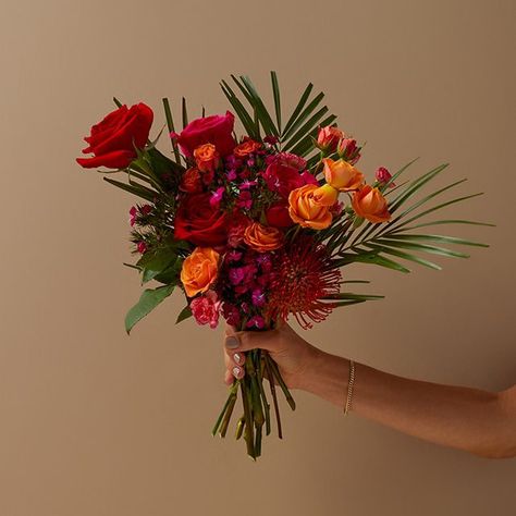 Orange & Dark Pink Roses + Orange Pincushion & Palm Leaves - The Bouqs Co. Spanish Flower Arrangements, Pink Orange Flower Arrangement, Burnt Orange Floral Arrangements, Summer Fireworks, Dark Pink Roses, Orange Wedding Bouquet, Pink Dianthus, Spanish Summer, Roses Orange