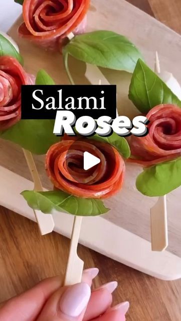 Emily | Simple Healthy Recipes on Instagram: "Salami roses 🌹 These are the perfect addition to your holiday charcuterie board! Ingredients Salami Bocconcini Basil Skewers Directions 1. Overlap 4 pieces of salami then fold in half 3. Tightly roll from one side to the other 4. Add to a skewer with basil and bocconcini Enjoy x #salamirose #charcuterieboard #holidayappetizers #cheeseboard #kitchenhacks #foodhacks #holidayrecipes #charcuterie #entertaining #holidayentertaining #countdowntildinner #christmasrecipes" Salami Flowers Video, How Do You Make A Salami Rose, Salami Roses How To, How To Make Salami Roses Video, Retro Appetizers, Charcuterie Board Ingredients, How To Make Salami Roses For Charcuterie Board, Holiday Charcuterie Board, Holiday Charcuterie