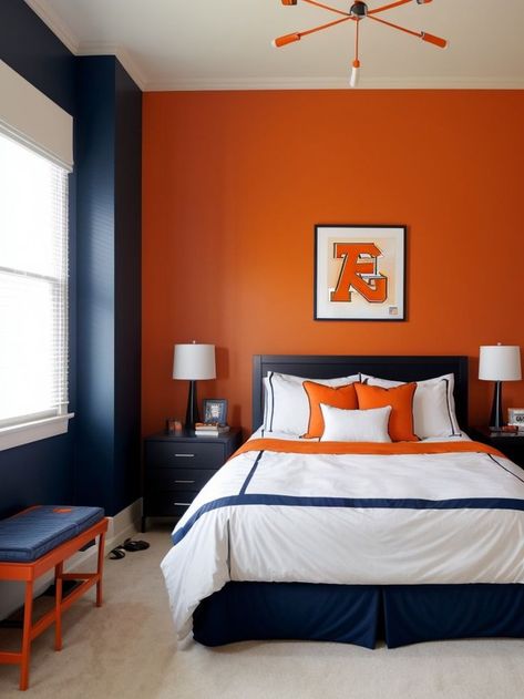 Create a vibrant and energetic boys bedroom by adding an orange accent wall, complemented with a cool sports-themed wallpaper. Complete the look with sleek black furniture and pops of blue for a modern and stylish space. Bedroom Orange Accents, Accent Wall Boys Bedroom, Boys Bedroom Orange, Orange Accent Wall, Orange Accent Walls, Sports Themed Bedroom, Blue Boys Bedroom, Orange Bedroom Ideas, Orange Bedroom