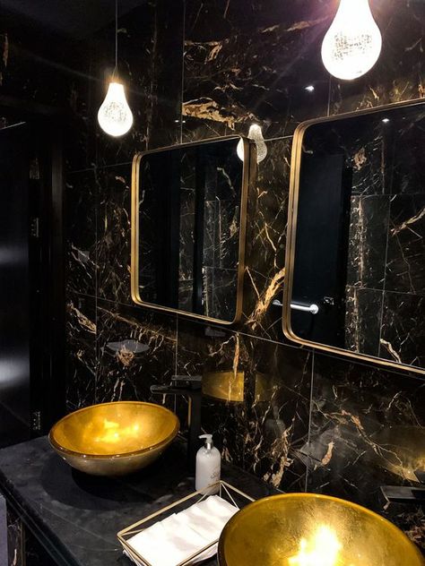 a refined powder room with black marble tiles, gold sinks, gold frame mirrors and catchy pendant lamps Restaurant Toilet Design, Gold Tiles Bathroom, Restaurant Toilets, Gold Bathroom Decor Ideas, Black And Gold Bathroom Decor, Black Marble Tile, Gold Toilet, Toilette Design, Gold Bathroom Decor