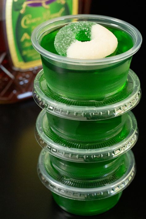 Four 2oz portion containers filled with Crown Apple jello shots are stacked on top of one another in front of a bottle of Crown Apple. Green Apple Fireball Jello Shots, Fairy Jello Shots, Apple Whiskey Jello Shots, Apple Jello Shots Recipes, Green Halloween Jello Shots, Crown Royal Apple Jello Shots, Jello Shots Fall, Apple Crown Jello Shots, Green Apple Jello Shots Recipes