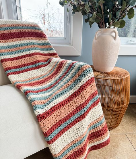 A striped crochet blanket draped over a white sofa beside a wicker side table and a ceramic vase with greenery. Striped Blanket Pattern, Crochet Striped Blanket, Crochet Bunny Blanket, Crochet Striped Blanket Pattern, Crafts For Halloween, Modern Haken, Crochet Star Stitch, Blanket Pattern Crochet, Striped Crochet Blanket