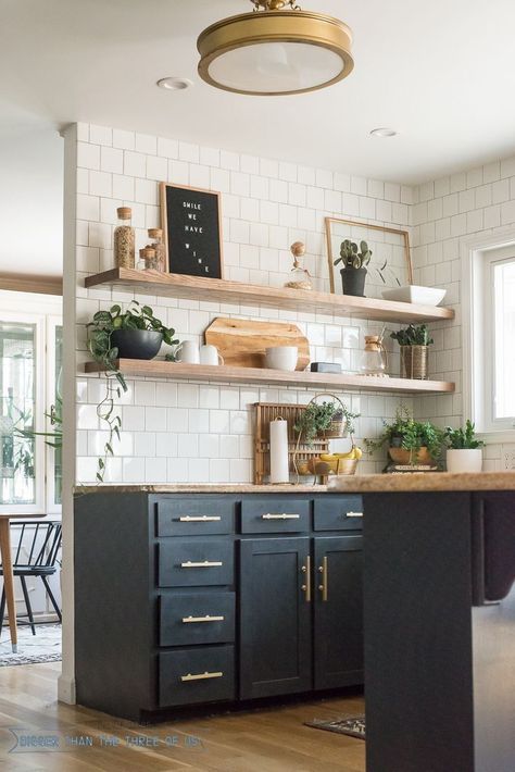 Dark cabinets, warm metallic hardware, and bright subway tile. Interior Boho, Open Kitchen Shelves, Kitchen Decor Modern, Estantes Flotantes, Black Cabinets, Kitchen Inspo, Trendy Kitchen, Decor Minimalist, Kitchen Remodel Idea