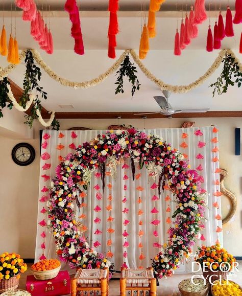 Traditional Indian Decor with tassels and flowers. Ring Backdrop with tassel strings on the ceiling. Contact us for further details.

#tassels#flowers#ring#backdrop#mehendidecor#traditionaldecor#weddingdecor#indianweddingdecor#thedecorcycle Ring Backdrop Ideas, Ganpati Ring Decoration, Flower Ring Backdrop, Indian Gender Reveal Ideas, Ring Backdrop Decoration Ideas, Engagement Indian Decoration, Ring Ceremony Decoration Indian, Rice Ceremony Decoration Indian, Traditional Baby Shower Indian