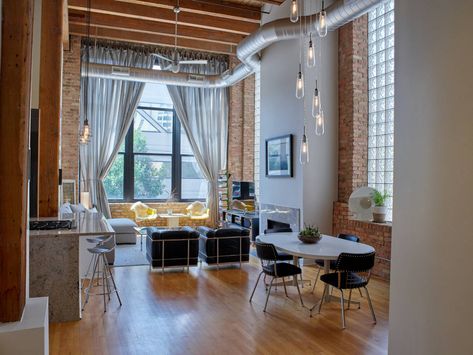 Spacious and dreamy timber loft apartment in the West Loop neighborhood of Chicago with exposed brick, exposed duct work, hardwood floors, drop industrial lighting, and glass block window | Domu Chicago Apartments Chicago Loft Apartment, Loft Apartment Industrial, West Loop Chicago, Chicago Lofts, Chicago Apartments, Glass Block Windows, Chicago Apartment, Glass Block, Top Restaurants