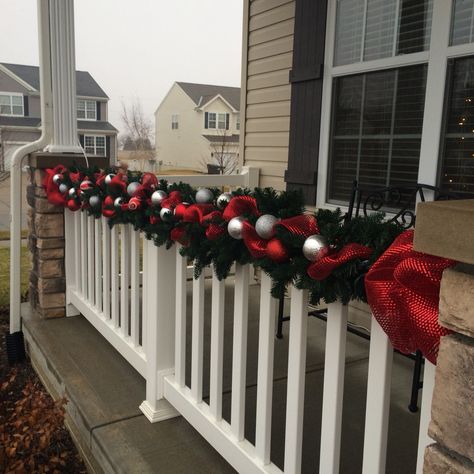 Garland on the front porch. Garland On Front Porch Pillars, Christmas Porch Banister Decorations, Balcony Railing Christmas Decor, Porch Railing Christmas Decorations, Outdoor Banister Christmas Decor, Patio Decorating Ideas Christmas, Balcony Ideas Christmas, Outdoor Christmas Balcony Ideas, Apartment Outdoor Christmas Decor