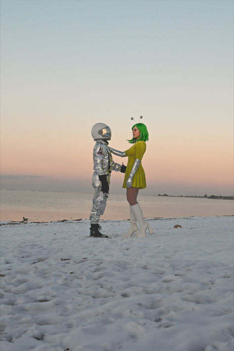 Alien and Astronaut Halloween costumes on a snow day sunset photography Martian And Astronaut Costume, Nasa Astronaut Costume, Mod Alien Costume, Pinup Alien Costume, Vintage Space Costume, Alien Halloween Costumes Diy, Space Babe Costume, Retro Alien Costume Women, Aliens And Astronauts Costume