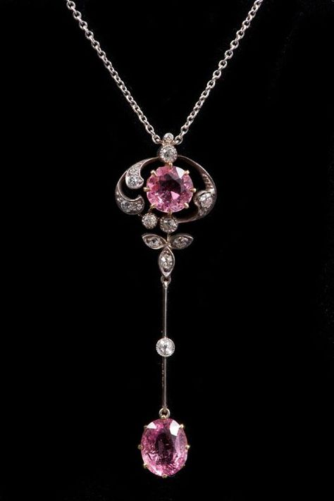 Edwardian diamond and pink tourmaline pendant on chain, the central round mixed-cut pink tourmaline estimated to weigh approximately 1 carat, in claw setting within an Art Nouveau open-work foliate scroll design set with old cut diamonds with a further oval mixed-cut tourmaline estimated to weigh approximately 1.25 carats, suspended from a knife-bar and diamond link, on a platinum trace chain. Fantasy Lagoon, Kristina Webb, Bijoux Art Deco, Grandmother Jewelry, Bijoux Art Nouveau, Edwardian Jewelry, Tourmaline Pendant, Claw Setting, Art Nouveau Jewelry