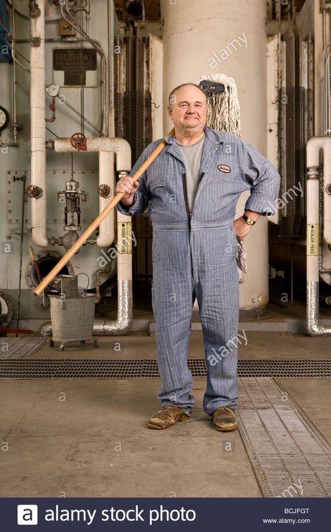 Male Caucasian in blue custodian/janitor overalls in factory setting including boiler, pipes, valves. He is holding mop. Stock Photo Janitor Uniform Women, Janitor Outfit, Janitor Character Design, Janitor Costume, Janitor Aesthetic, Janitor Uniform, Mechanic Uniform, Victorian Factory Worker, Coverall Men