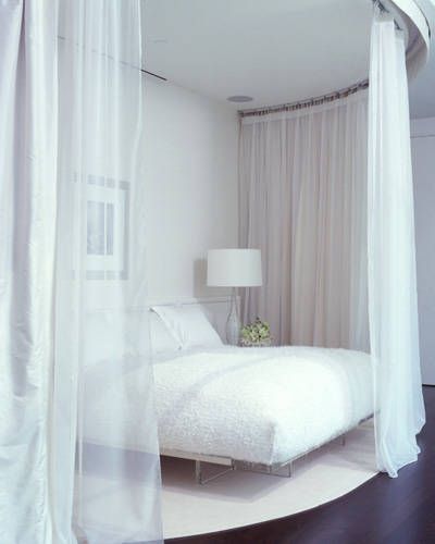 To make the bed feel sensual and mysterious, designer Benjamin Noriega-Ortiz enclosed it in a layer of transparent fabric. The mattress has a thick feather pillow on top that helps create the illusion of being on “cloud nine.” By keeping the bed off the floor, the designer reinforced the idea of floating. Curtain Over Bed, Feng Shui Bedroom, Feather Pillow, Transparent Fabric, Romantic Room, White Bed, Dekorasi Kamar Tidur, Relaxing Bedroom, Furniture Inspiration