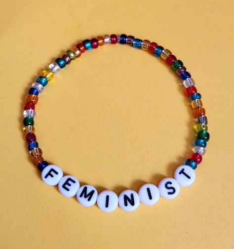 Feminist bracelet with gorgeous jewel coloured seed beads. Colour pattern of beads will vary 💕   Bracelets are elasticated and made with high quality elastic. Please choose your size at check out. Thank you 💕 Feminist Bracelet, Beaded Ideas, Blessing Beads, Feminist Jewelry, Bracelet Craft, Bracelet Craft Diy, Feminist Gift, Jewel Colors, Jewelry Making Necklace