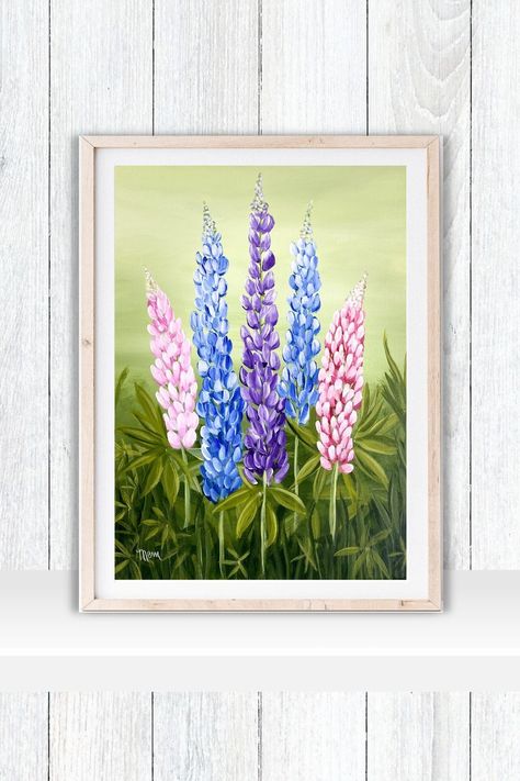 A framed acrylic painting print of 5 lupines.  Lupines are pink blue and purple on a light green background with vibrant green leaves and grasses at the base.  The print is framed in a light wooden frame with a white mat.  The frame sits on a white shelf against a white wall. Lupine Painting, Colourful Wall Decor, Lupine Flowers, Easy Canvas, Easy Canvas Painting, Flower Prints Art, Floral Prints Art, Floral Wall Art, Giclee Art