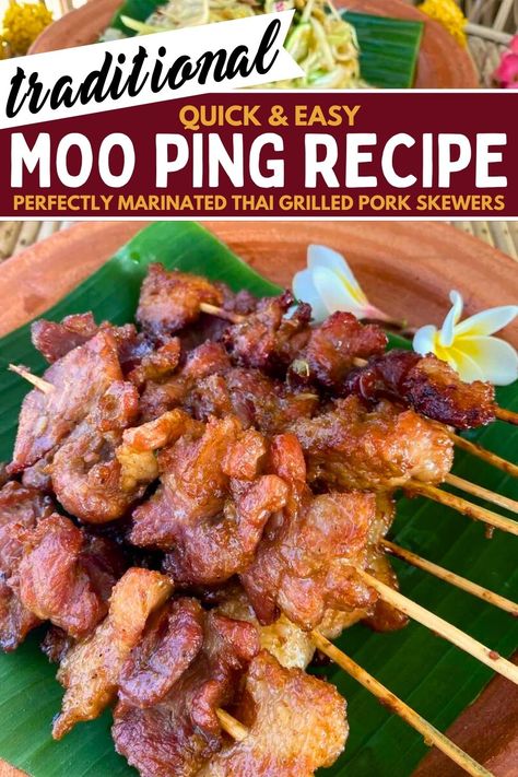 Several moo ping (Thai grilled pork skewers) on a banana leaf in a clay dish with 2 flowers in it as well. Thai Food For Party, Chinese Pork Skewers, Moo Ping Skewers, Thai Grilled Pork, Thai Pork Skewers, Moo Ping Recipe, Vietnamese Pork Skewers, Thai Authentic Recipes, Jok Moo Recipe