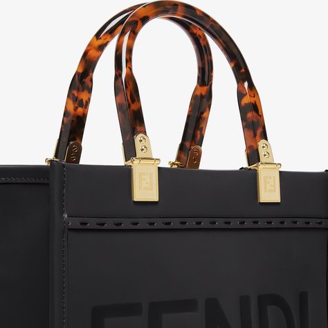 Small Sunshine Shopper bag made of black leather with hot-stamped FENDI ROMA lettering and stiff tortoiseshell plexiglass handles. Features a spacious lined internal compartment, edges in tone-on-tone leather, and gold-finish metalware. Can be carried by hand or worn on the shoulder thanks to the two handles and detachable shoulder strap. Made in Italy Fendi Sunshine, Leather Bags For Women, Fendi Logo Design, Fendi Store, Fendi Logo, Leather Denim, Black Leather Bags, Shopper Bag, Sandal Fashion