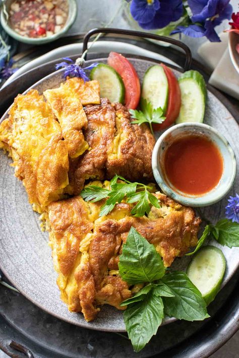 Thai Pork Omelette (Kai Jeow Moo Sap) is one of Thai cuisine's easiest and most delicious egg dishes. This beautiful Thai omelet is a universal food Thai people enjoy, from street food vendors to Thai restaurants and homes. Learn how to make this comforting Thai-style omelette in different ways to enjoy it anytime. #thaiporkomelette #porkomelette #thaiomelette #thaiomelet #Kaijiawmoosap #thaifriedeggs #thaieggs #omelette Thai Egg Recipes, Thai Omelette Recipe, Thai Minced Pork, Thai Omelette, Omelette Recipe, Thai Street Food, Sriracha Sauce, Thai Dishes, Egg Dish