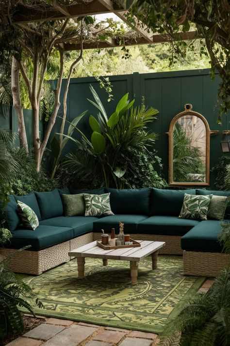 "Turn your backyard into a tropical paradise with an inviting lounge area. This setup features a green sectional sofa, a rustic wooden coffee table, and a patterned rug, all surrounded by dense greenery and illuminated by soft, natural light for a jungle-inspired retreat." #BackyardParadise #LoungeDesign #TropicalDecor #RusticOutdoorSpaces #EcoLiving #NatureInspired Shaded Pergola, Green Sectional Sofa, Tropical Lounge, Rustic Outdoor Spaces, Rustic Wooden Coffee Table, Maximize Small Space, Outdoor Lounge Area, Greenery Decor, Cozy Backyard