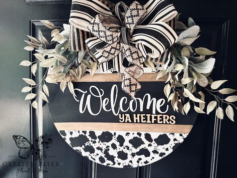 18” Hand-Painted Wood Round Door Hanger – Cow Print “Welcome Ya Heifers!” Add a touch of farmhouse charm to your home with this 18-inch wood round door hanger! Hand-painted in a trendy cow print design, this piece is perfect for bringing rustic warmth and humor to your entryway. Featuring bold lettering that says, “Welcome Ya Heifers!”, this door hanger is a fun and inviting way to greet your guests. The natural wood finish complements the playful design, making it a perfect fit for any far... Cow Print Welcome Sign, Door Hanger Ideas, Cow Print Design, Hanger Ideas, Round Door Hanger, Bold Lettering, Unique Fall, Round Door, Farmhouse Charm