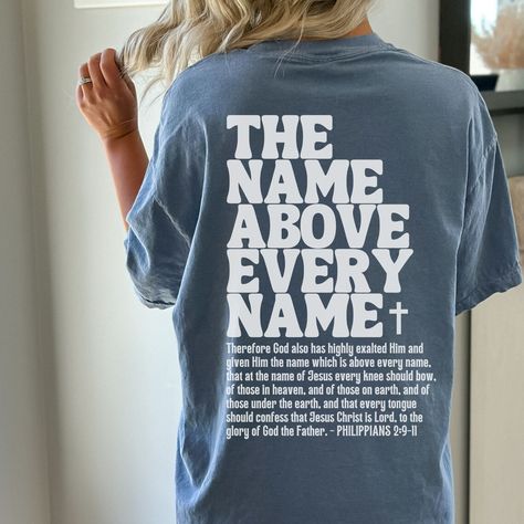 Comfort Colors Christian Shirt, Jesus T-Shirt, The Name Above Every Name, Christian Shirts, Phillipians 2:9-11, Bible Verse Back Scripture Tee THE NAME ABOVE EVERY NAME ❤  PLEASE NOTE THIS IS A BACK PRINT TEE. THE FRONT IS PLAIN 😊 ✦ FEATURES ✦ ✿ What makes these t-shirts so special? Well, there's an art to making a brand new shirt feel vintage and familiar - and Comfort Colors have perfected it! If you're looking for that faded, well-loved t-shirt vibe in on trend colors, then this is the tee for you. ✿ Constructed of 100% ring-spun USA cotton making it  soft and comfy.  ✿ Preshrunk, soft-washed, garment-dyed fabric. Double needle topstitched neckline for added durability.  ✿  Direct to garment printing is used. Meaning ink is printed into the cotton (not sitting on top of garment like vi Christian Gift Shop, Christian Clothing Brand, Jesus Clothes, Bible Shirts, Christian Shirts Designs, Church Shirt, Jesus Tshirts, Christian Tees, Christian Shirt